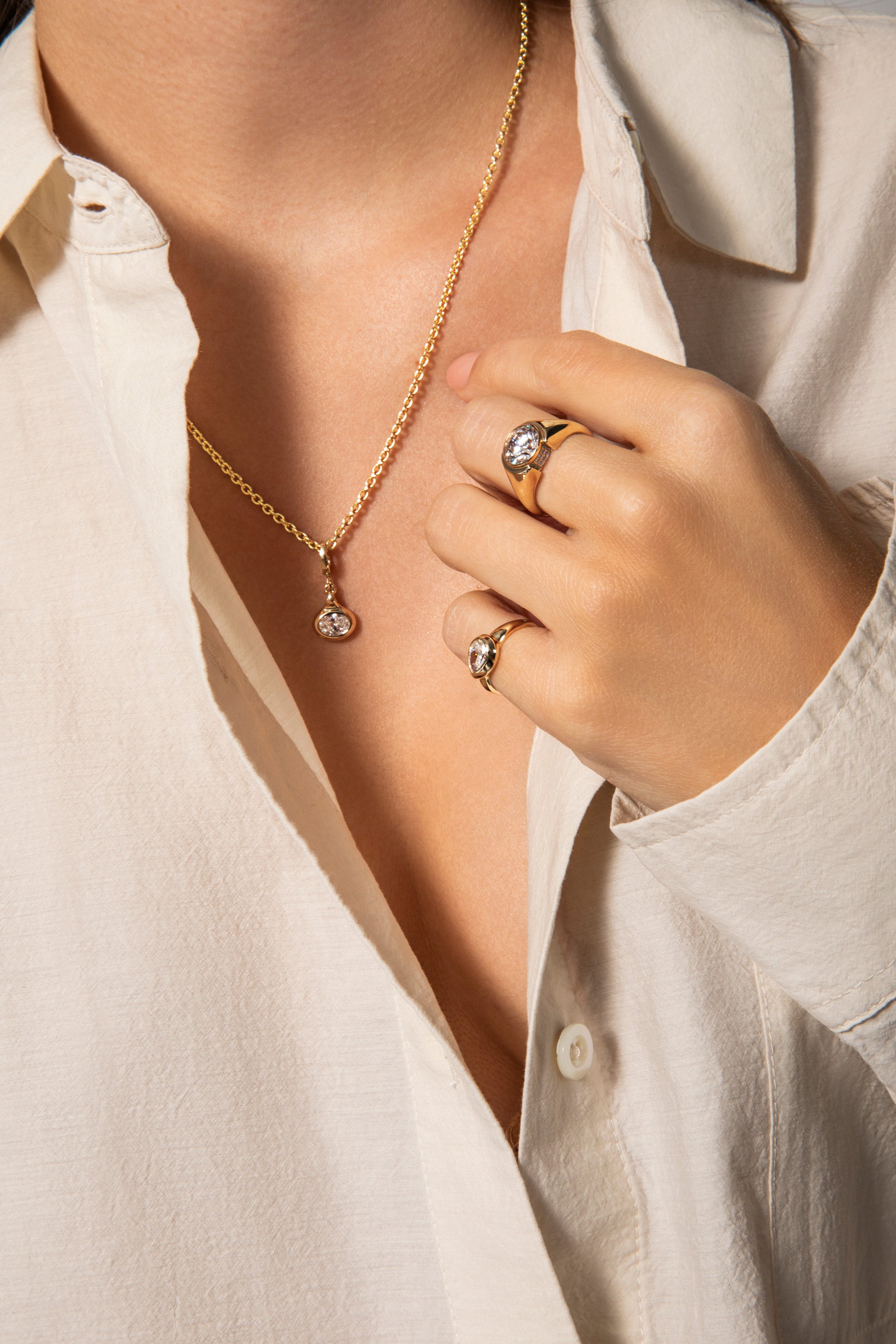 A models wears teh mother's day charm collection on a 14k gold chain and paired with chunky gold and diamond rings