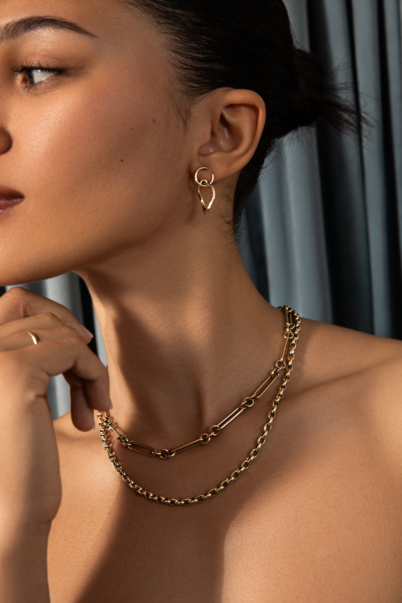 Avony Modeling Bold Gold Holiday Edit featuring the mixed link chain necklace, chunky rolo chain necklace and twisting drop hoops. Shop the bold gold colleciton