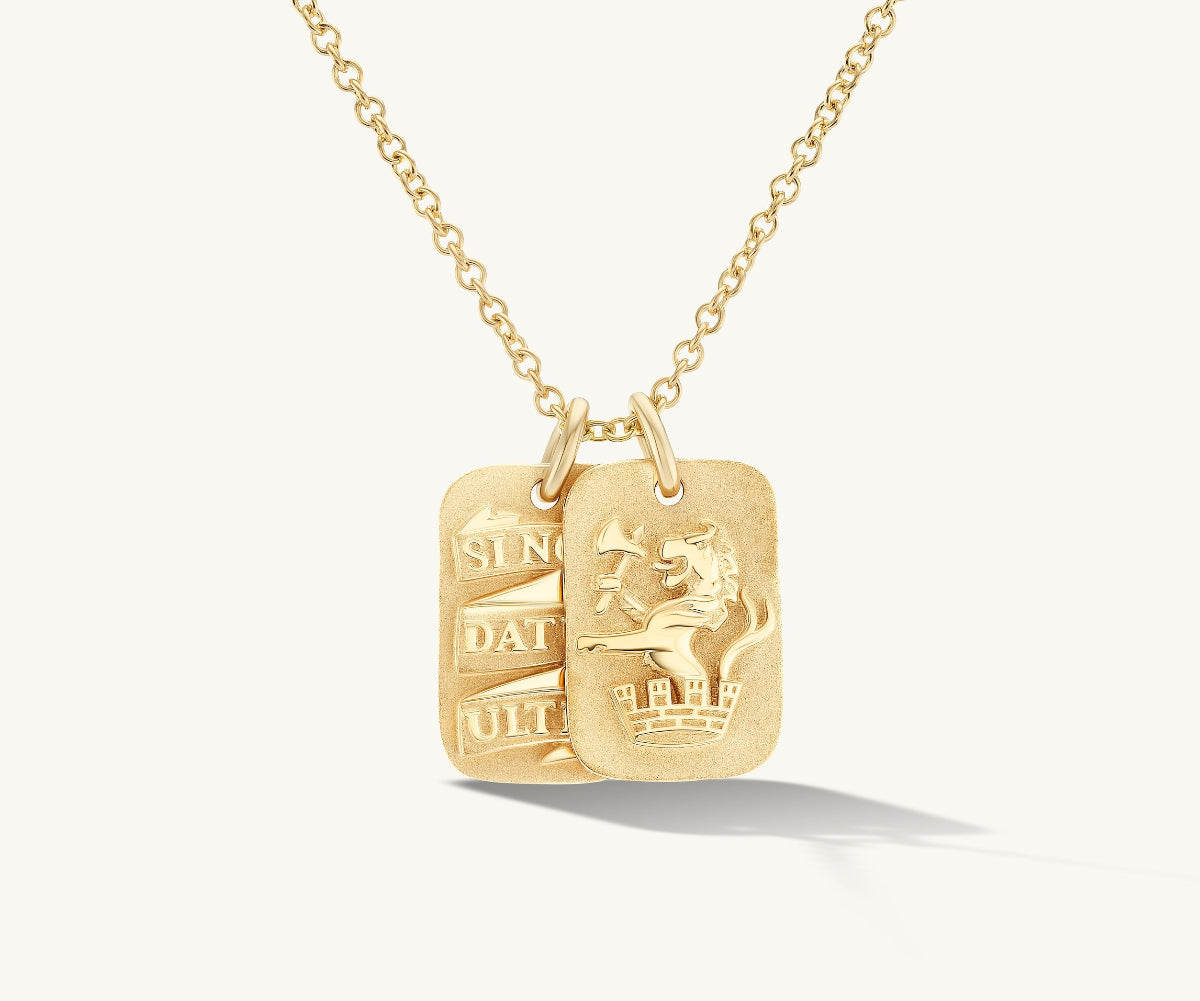 Gold necklace with two engraved tags on a white background