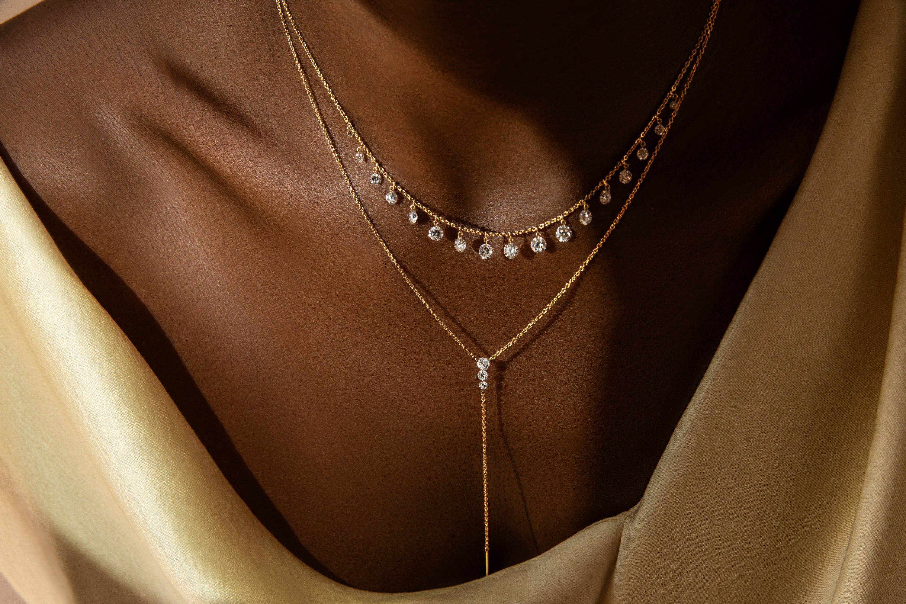 Gold necklace with small diamonds on a brown fabric background