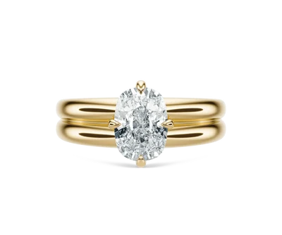 Oval-cut diamond engagement ring on a yellow gold band.