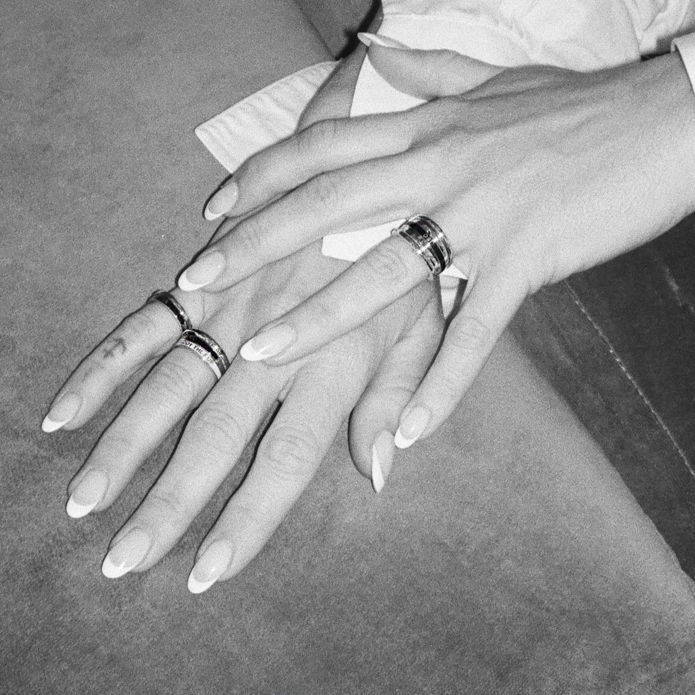 Zosia Mamet's hand modeling her collections diamond and enamel rings. Styled for fall in a black and white image. Shop black patina and enamel styes - moody and romantic for fall