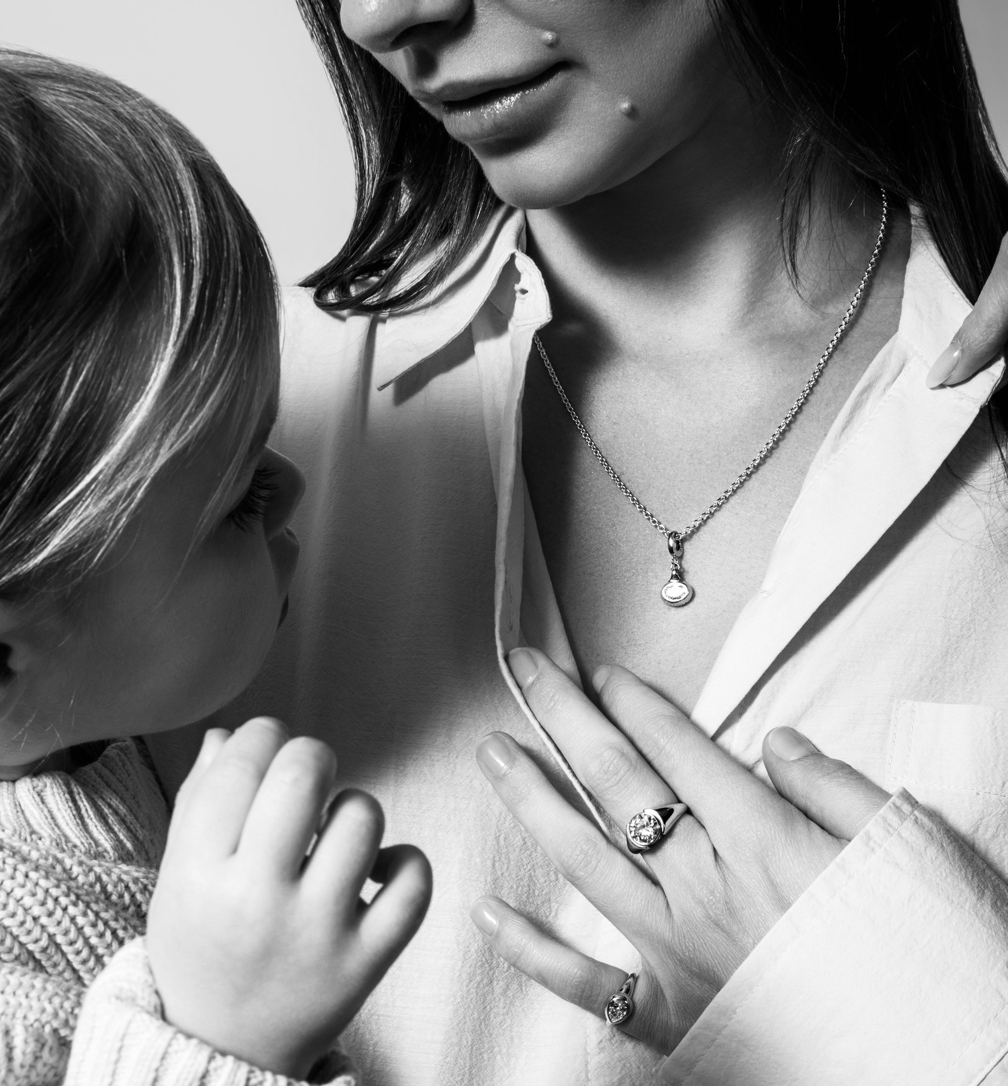 Woman and child with jewelry, including rings and necklaces, in a close-up shot.
