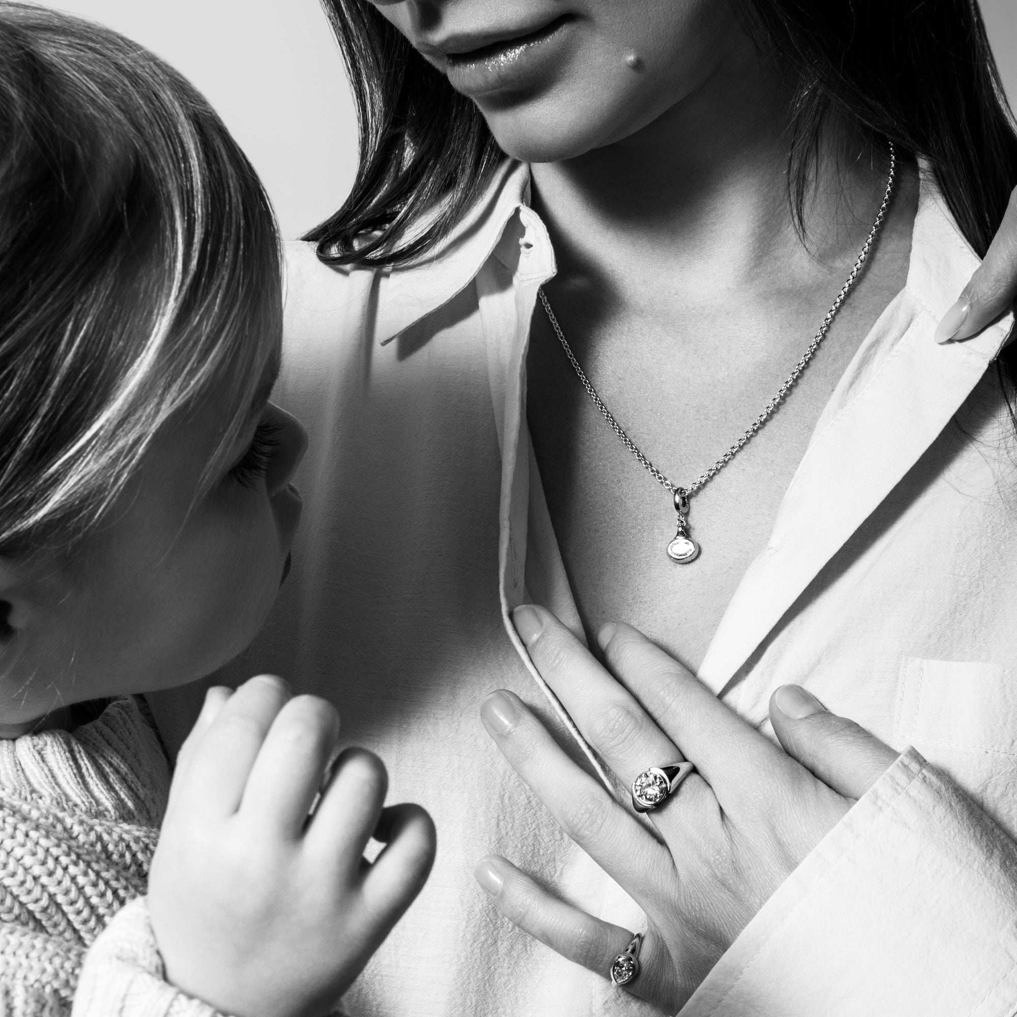 Woman and child with jewelry, including rings and necklaces, in a close-up shot.