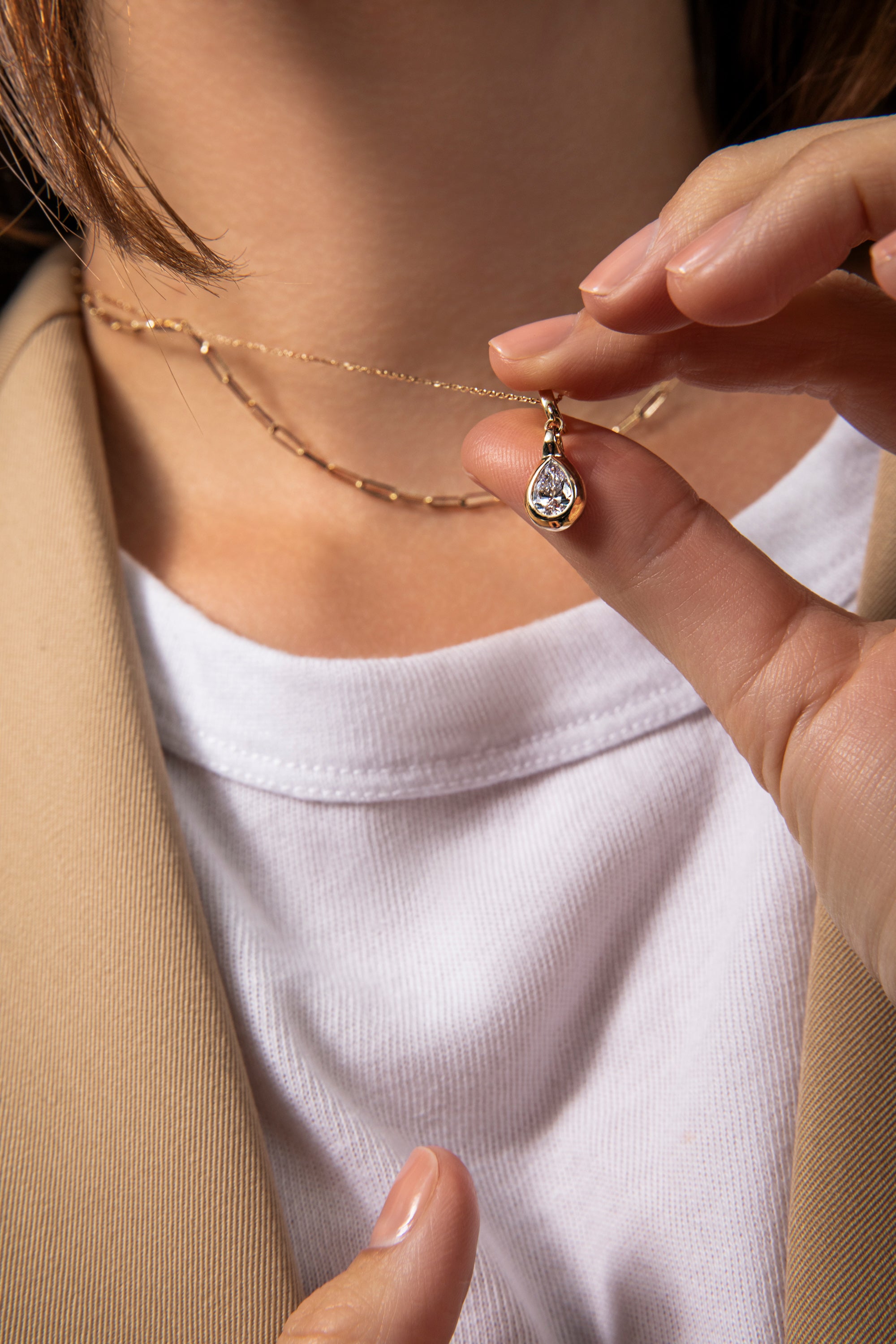 model holding up pear venus neckace charm