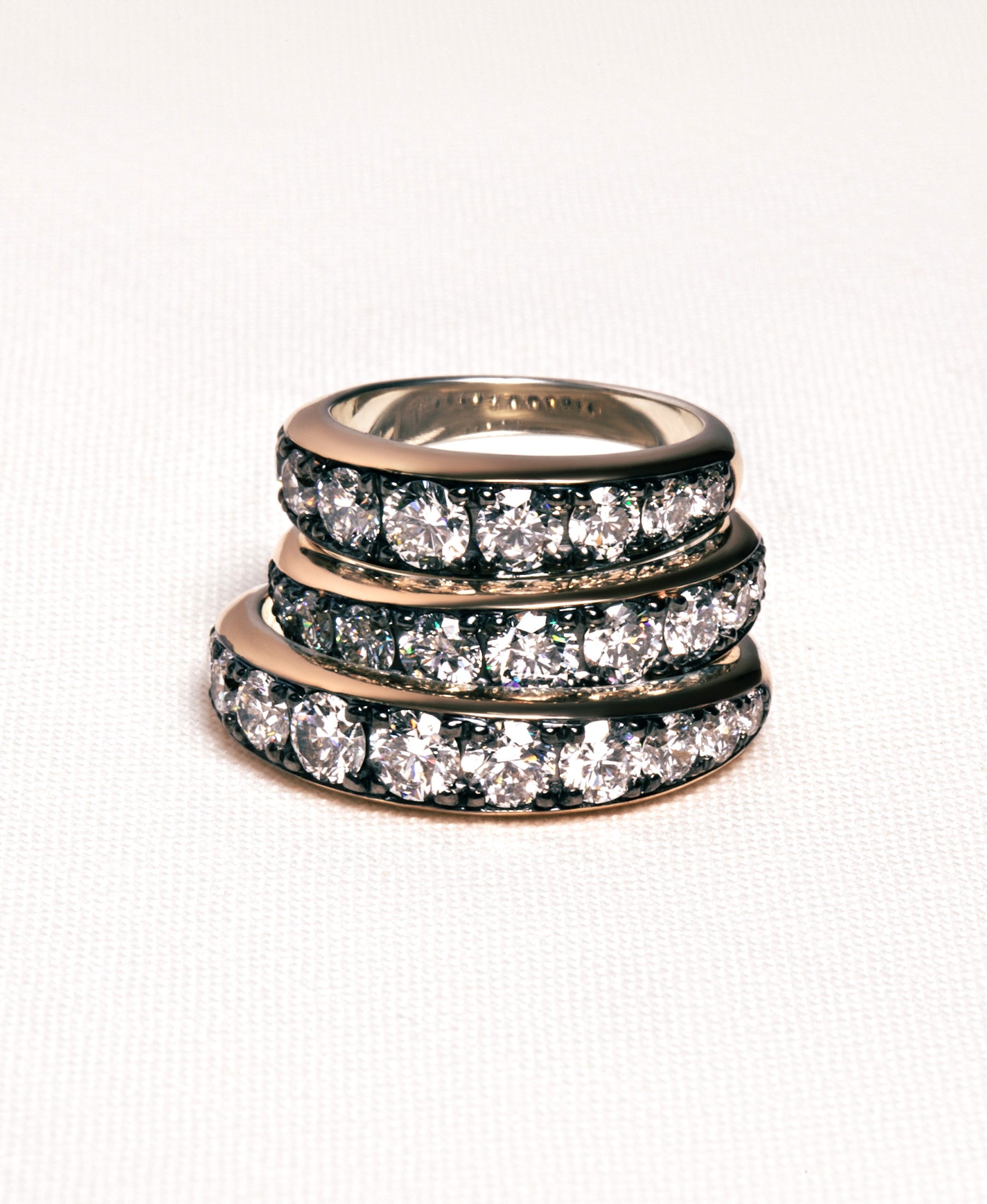 a stack of thick patina diamond stacking bands on a white background