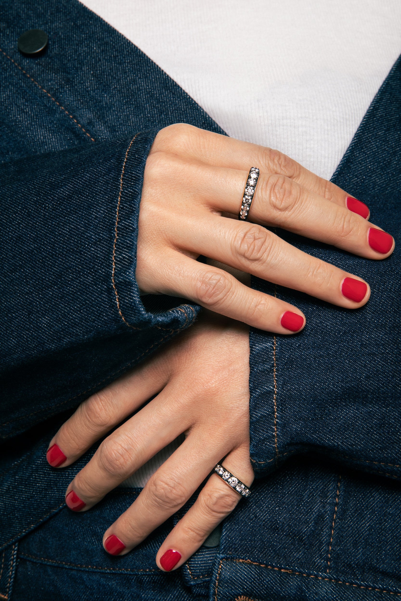 Close up of model wearing the Thick Patina Diamond Band. A Domed front of solid 14k blackened gold an graduating lab grown diamonds, with a sterling silver back. 