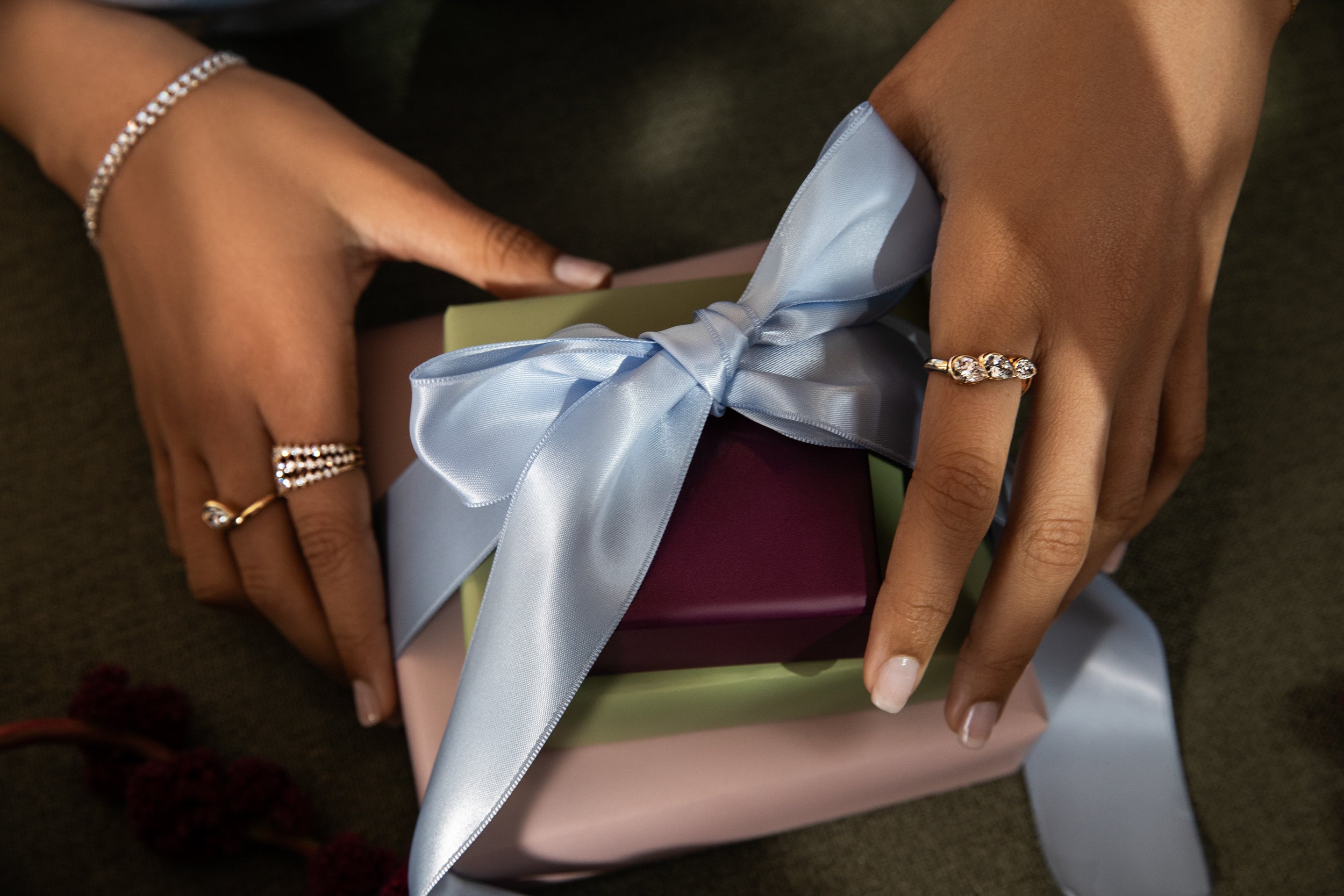 A models wears new sophie ratner diamond and gold rings holding the holiday gift box promotion. Spend $1000+ and choose a free pair of diamond studs or a diamond necklace. Spend $2,000+ and get both. automatically added to qualifying carts. while supplies last.