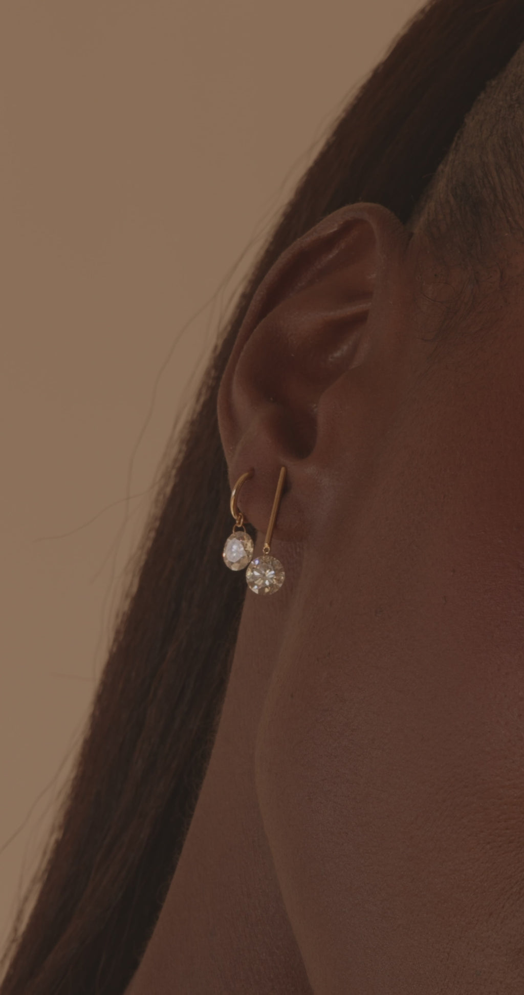 A video showing a model wear the 1 carat round and gold bar earring in their first pierceing and the 1 carat round earring in the second piercing